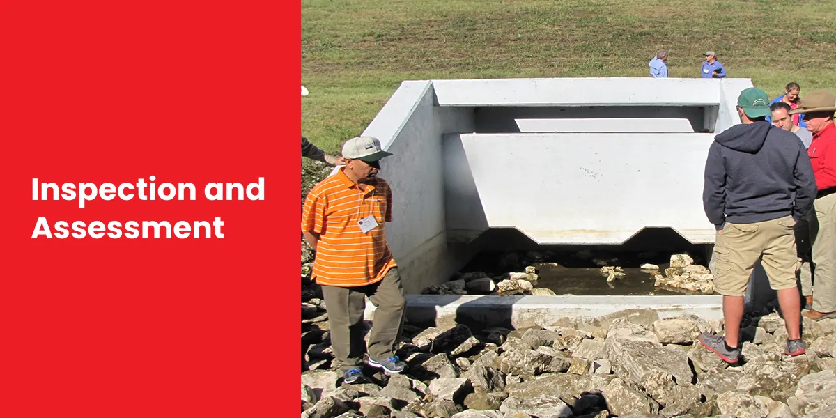 Group of people inspecting a concrete drainage structure with rocky surroundings