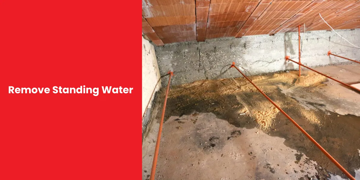 Standing water in a crawl space with drainage pipes installed to remove water buildup.