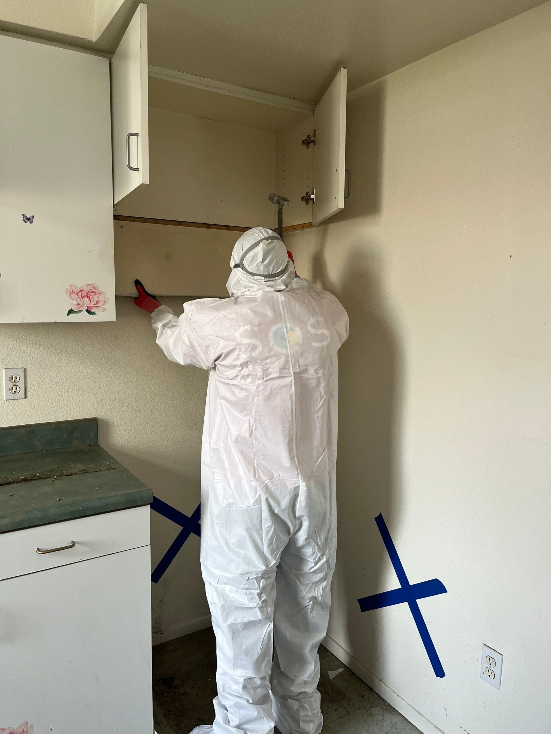 SOS Restoration technician cleaning kitchen cabinetry during mold remediation in Camarillo, CA