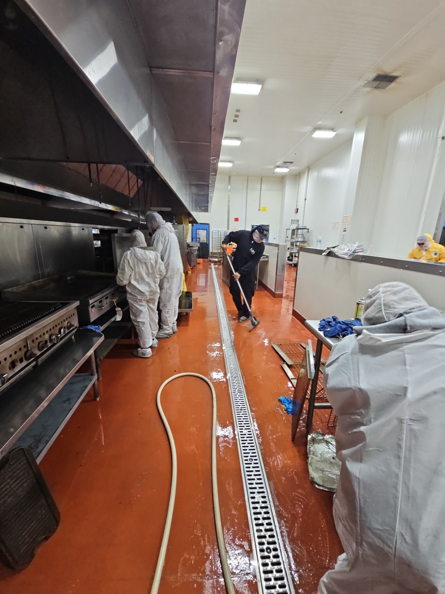 SOS Restoration technicians in protective suits during commercial kitchen restoration in Inglewood, CA